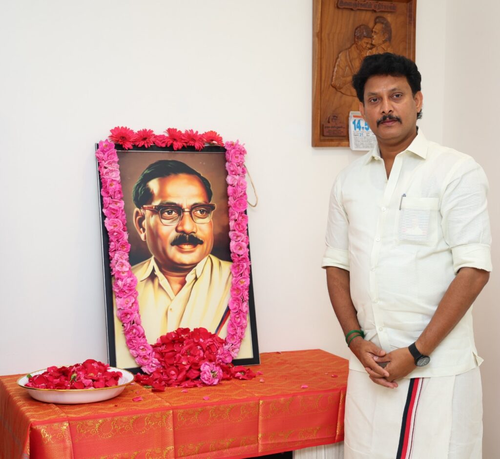 Anbil Mahesh Poyyamozhi garlanding the portrait of his grandfather, Anbil Dharmalingam, on his birth anniversary.