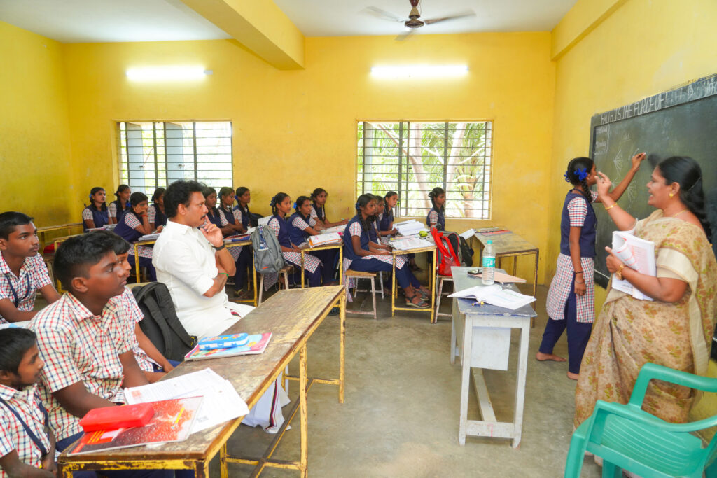 Anbil attending class taken by a student in govt school during 234/77 visit
