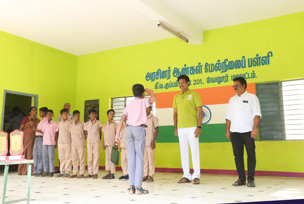 A student saluting the அமைச்சர் அன்பில் மகேஸ் பொய்யாமொழி during a visit