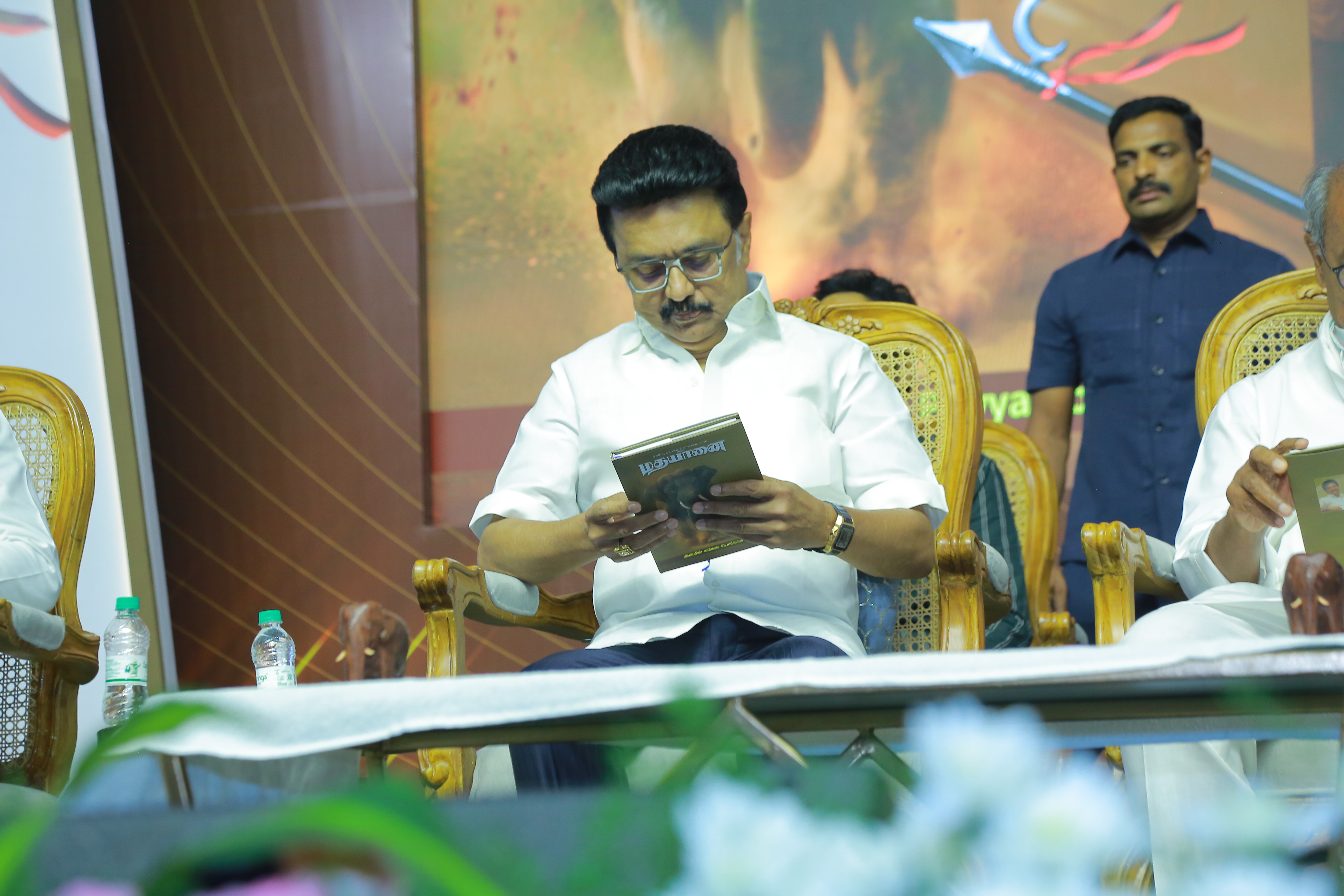 Chief Minister M.K. Stalin and Digvijaya Singh engaged in a thoughtful conversation during the "Madhayaanai" book launch, seated on stage amid floral arrangements.