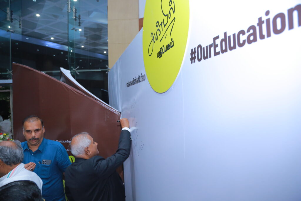Former Chief Justice V. Gopala Gowda signing the pledge wall at the "Madhayaanai" event, endorsing the call for educational federalism.