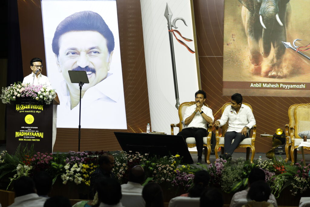 Anbil Mahesh Poyyamozhi, Udhayanidhi Stalin, and M. K. Stalin seated onstage, displaying focused attention at the launch of "Madhayaanai," criticising NEP 2020.