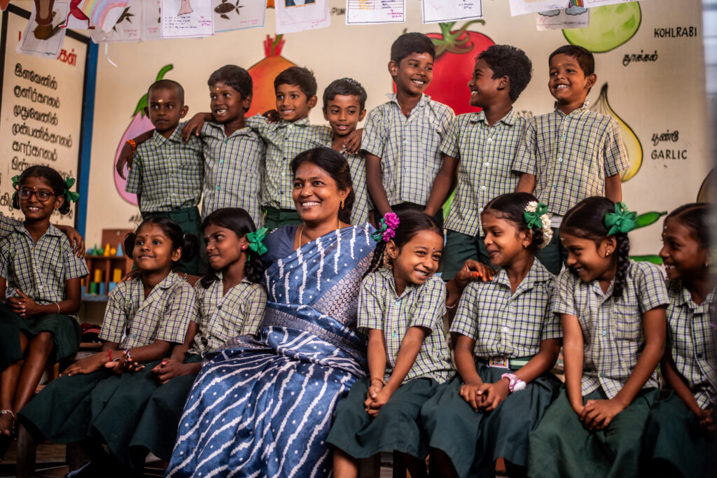 A government School teacher interacting with kids at school joyfully